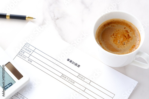 事業計画書 - 新規事業の立ち上げに先立ち、事業計画書を作成する起業家のイメージ
