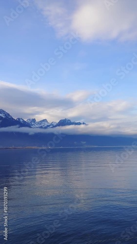 Majestic snow capped mountain range reflecting in Lake Geneva Switzerland