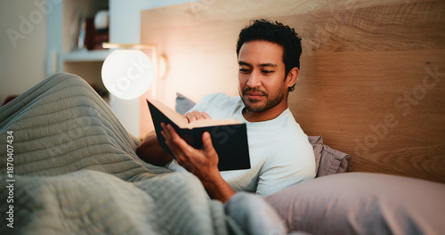 фотографія Reading, book and man in bedroom at night in home with relax for hobby, knowledge or entertainment