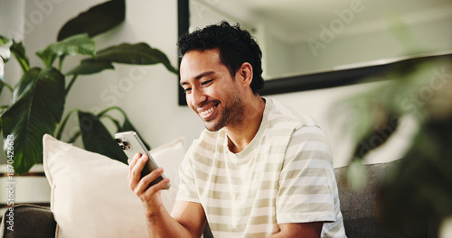 Fotografie Home, cellphone and happy man on couch, typing and social media with connection