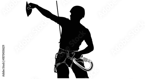 Silhouette of a rock climber preparing to ascend a climbing wall with safety gear