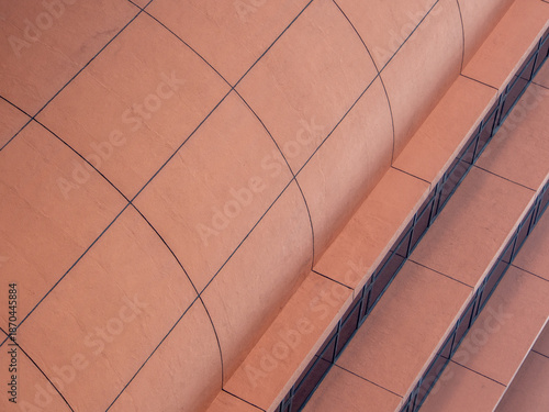 Close up of a red building exterior with rectangular pattern lines and shapes and geometrical feature.