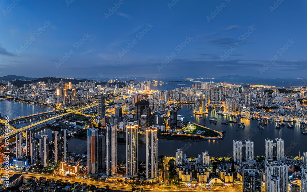 Naklejka premium Aerial view of the modern city skyline with illuminated buildings and bridges at night in Zhuhai, China.