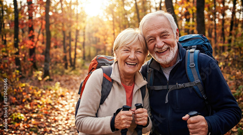 Happy seniors enjoying hike in colorful autumn forest, surrounded by vibrant foliage