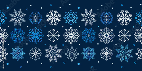 Seamless pattern of delicate white and blue snowflakes on a dark background