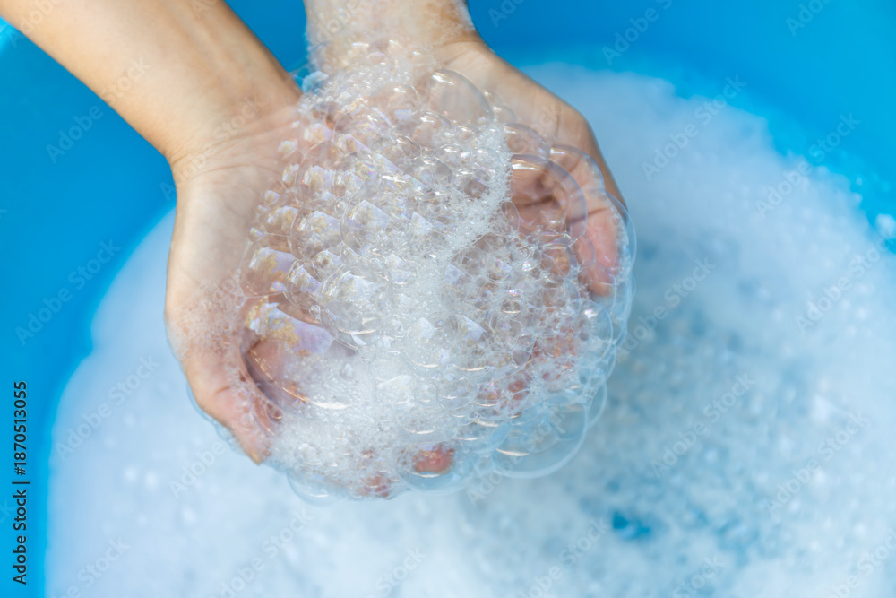 Fototapeta premium Hands Holding Soap Bubbles in Clean Water, Close-up, Wash hands hygiene, cleanliness, handwashing routine, and disease prevention through proper sanitation