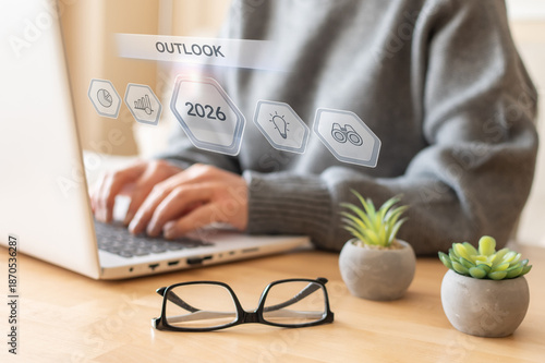 Bilde på lerret Person working on a laptop with a digital overlay showing outlook and 2026 icons
