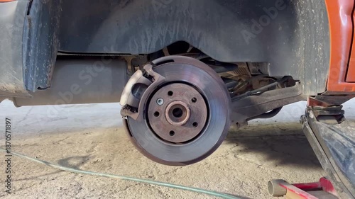 Close-up of a turning car brake disc in a garage