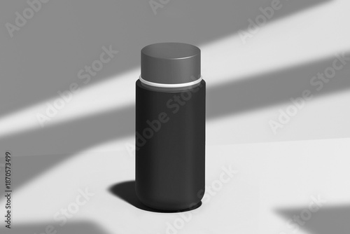 a black bottle with a gray background and a shadow of a window