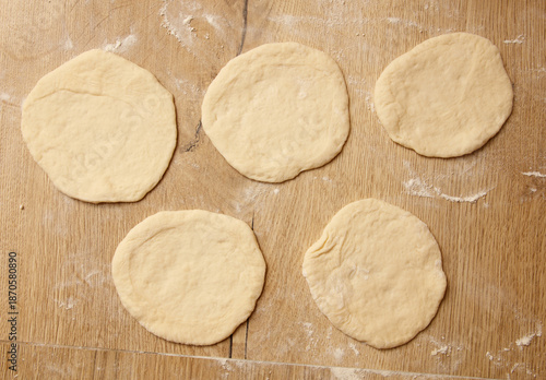 A wooden table with five doughnuts on it