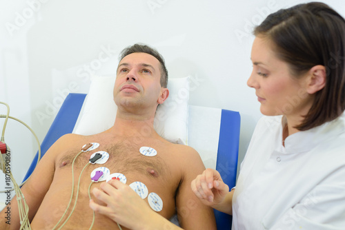 Nurse applying heart monitor pads to patient