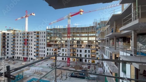 Construction site building cranes moving on a sunny day
