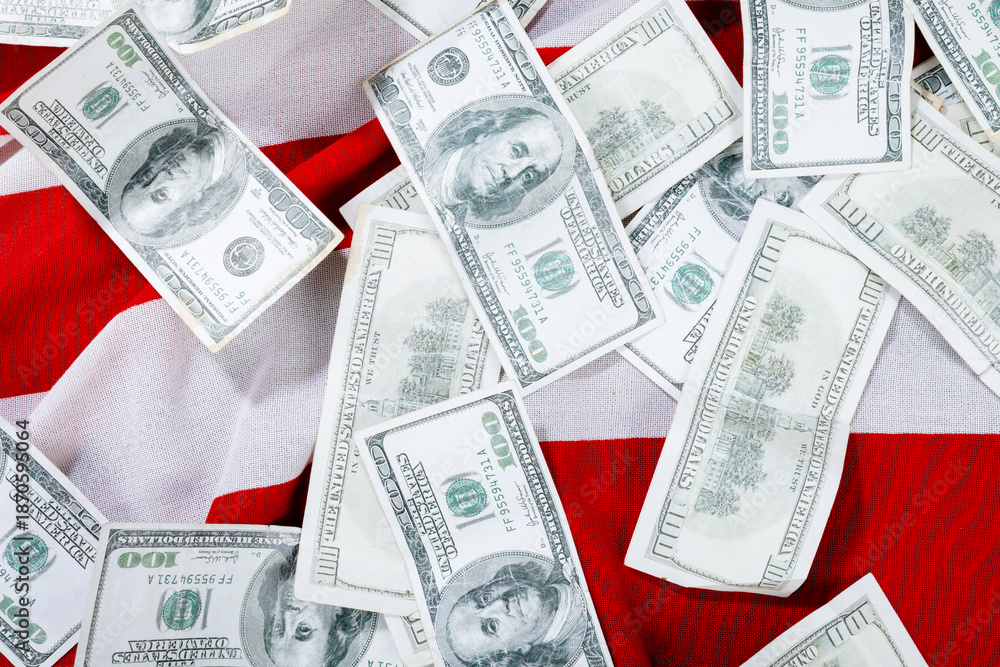 Fototapeta premium Portrait of benjamin franklin scattered on hundred dollar bills over american flag
