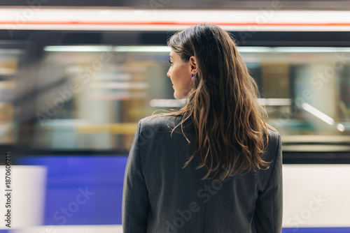 Businesswoman in business attire waiting on Madrid metro platform