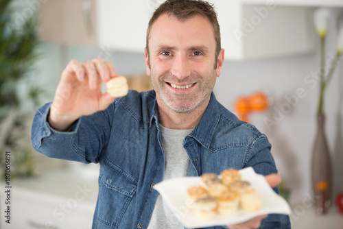 Canvas Print man offering a canape from the plate he is holding
