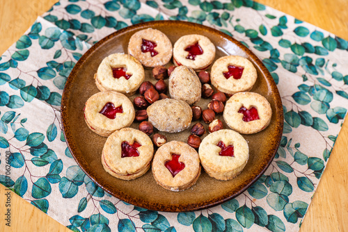 Christmas Linzer cookie and nut on plate, napkin on wooden table