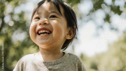 Joyful Asian Toddler Laughing Outdoors in Nature.