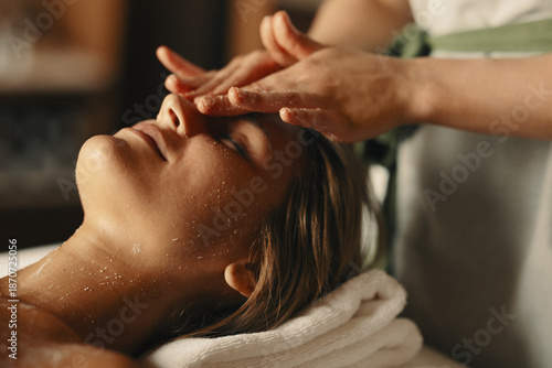 Relaxed woman receiving facial treatment at a spa salon for skincare