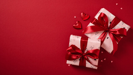 Two Valentine's Day gift boxes with heart decorations on a red background