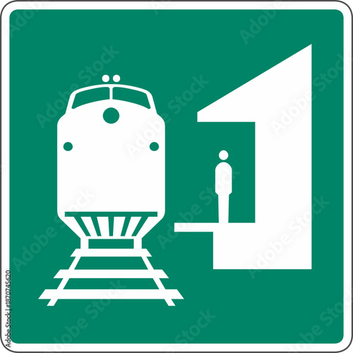 A green and white sign indicating a train platform with a person standing on it.