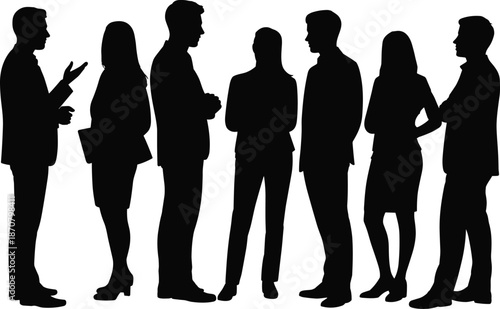 Group of seven people in business attire standing and conversing in a social setting with one person gesturing