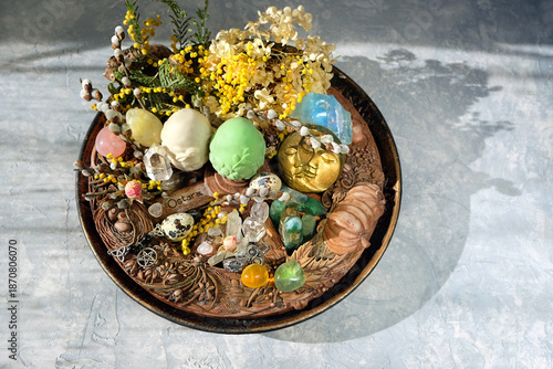 Wiccan altar for Ostara sabbat. witchcraft, magic ritual. wheel of the year, decorative eggs, amulets and talismans, crystals, flowers, willow twigs on table. Ostara holiday, spring equinox. flat lay