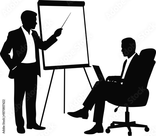 Two men in business suits discussing a presentation on a flip chart with one sitting and the other standing