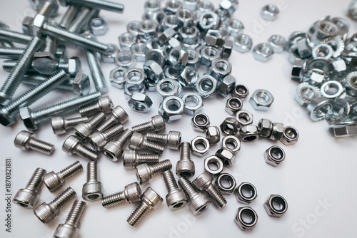 Billede på lærred Assorted industrial steel fasteners including hex bolts, flange nuts, and screws on white