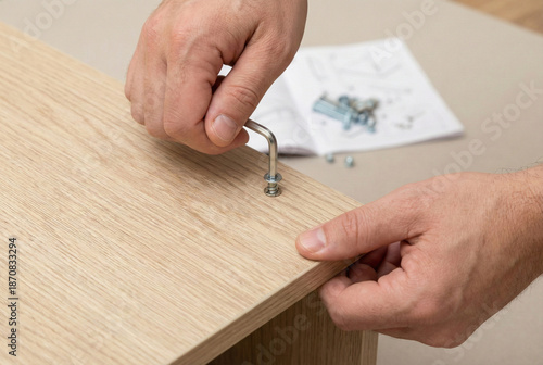Hands assembling flat-pack furniture with hex key on wooden board