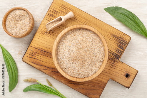 Fotografija Psyllium husk powder with fresh leaves on wooden background, top view