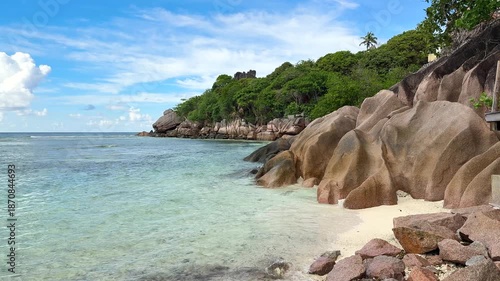 Explore rocky beach with clear water and green cliffs during sunny day