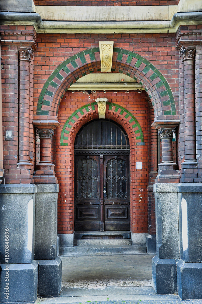 custom made wallpaper toronto digitalZabytkowy łuk z czerwonej cegły otacza ciężkie drewniane drzwi z ozdobnymi, żelaznymi moskitierami. Zielone akcenty z płytek, rzeźbione kolumny i zwietrzały kamień tworzą bogatą, ponadczasową fasadę.