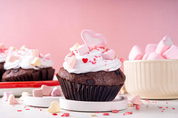 Valentine day tasty cupcakes treat with whipped cream, heart marshmallow and sugar sprinkles