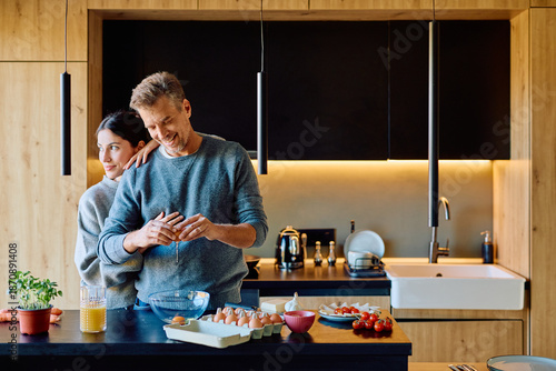 Quadro em tela Happy couple cooking breakfast in a stylish kitchen, sharing a moment of domesti
