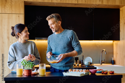 Картината върху платно Happy couple preparing breakfast in a stylish kitchen
