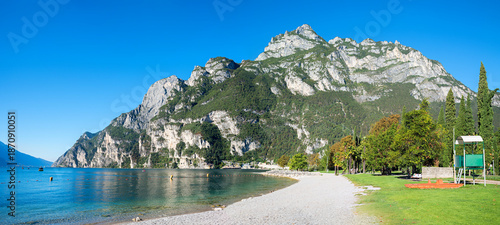 Billede på lærred lakeside Gardasee with sunbathing lawn and mountain view