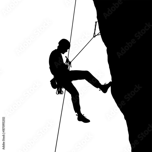 Silhouette of a Rock Climber Rappelling Down a Cliff Face.