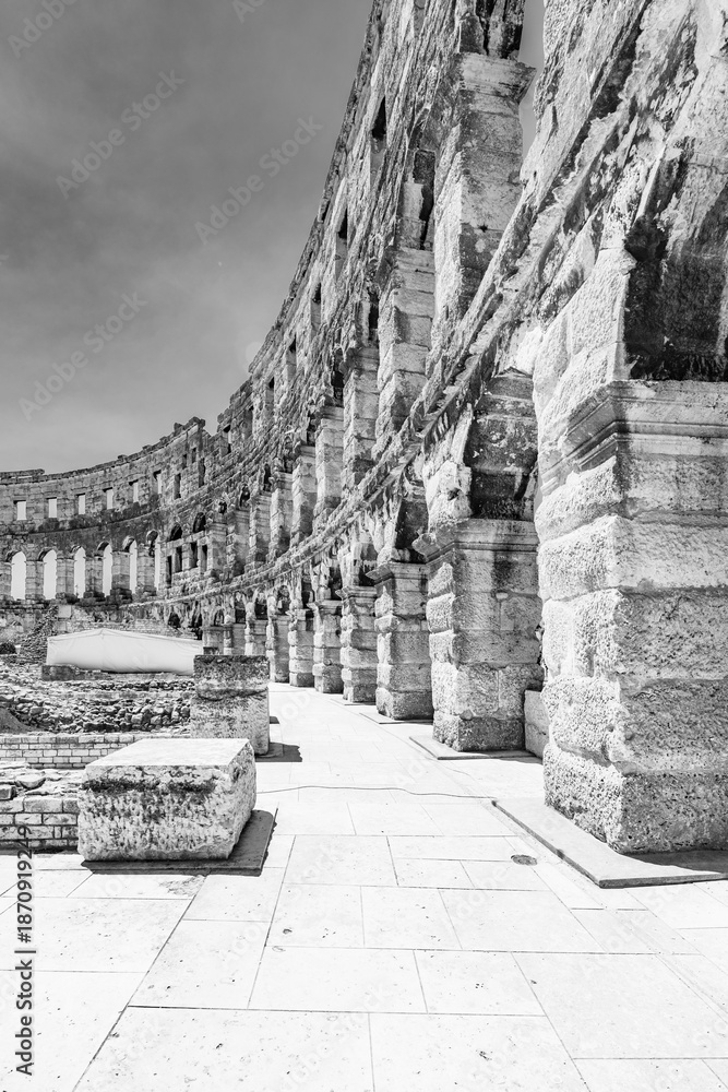 Naklejka premium The Roman amphitheatre in Pula, Croatia, stands as a remarkable example of ancient architecture. Constructed of stone, its impressive arches and columns tell stories of a vibrant history.
