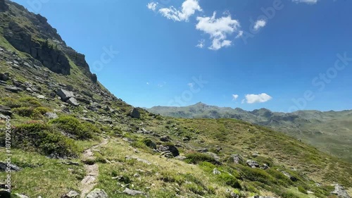 Panoramic mountain landscape in Koenigsleiten, Austria, with green hills, rocky terrain, and a vibrant blue sky