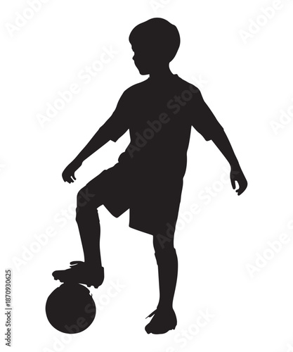 Silhouette of a boy with short hair standing with his foot on a soccer ball.