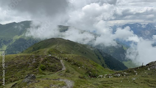 Panoramic Vista of Lush Green Mountains and Dramatic Clouds in the Summer Austrian Alps.
