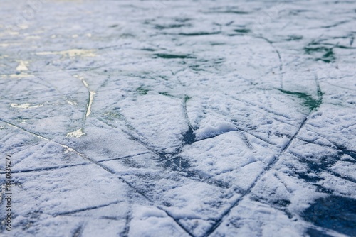 Explore the beauty of textured ice patterns under soft winter light at the local outdoor rink