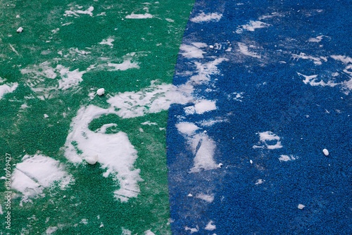 Colorful playground surface with scattered snow in a quiet winter scene