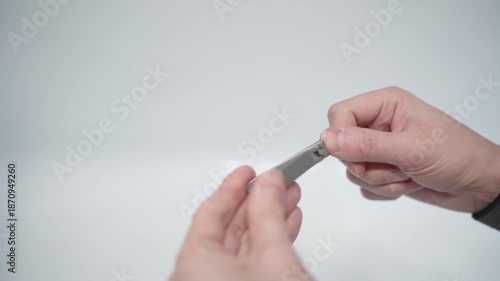 Cutting nails on a man's hand with nail tongs on a white background. Care for hands.