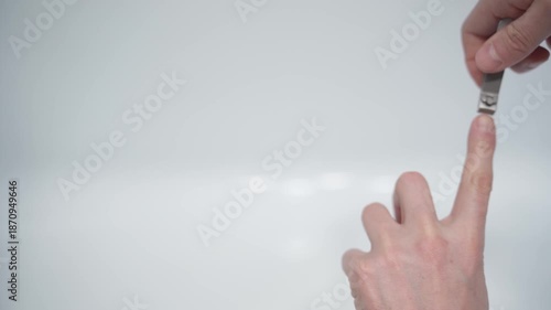 Cutting nails on a man's hand with nail tongs on a white background. Care for hands.