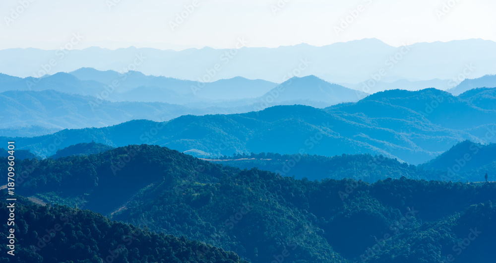 Naklejka premium Panoramic view of blue mountain range layers under a clear sky. Mountain scenic nature landscape for peaceful background and travel destination concept in Southeast Asia.