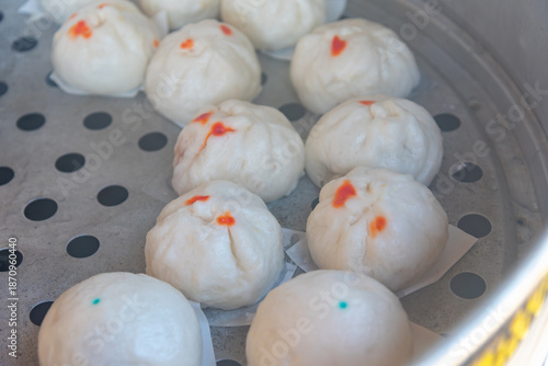 Freshly steamed buns or Salapao in a metal steamer pot. Traditional Chinese dim sum and Asian street food, soft and fluffy snack for breakfast or appetizer.