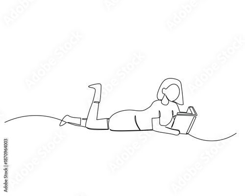 Woman lying on stomach using laptop computer relaxed.