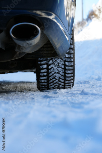 фотографія Close-up of car winter tire with snow on a frozen road