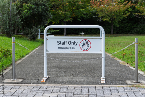 公園や施設の管理通路に設置された「Staff Only（関係者以外立入禁止）」の白いスタンド看板